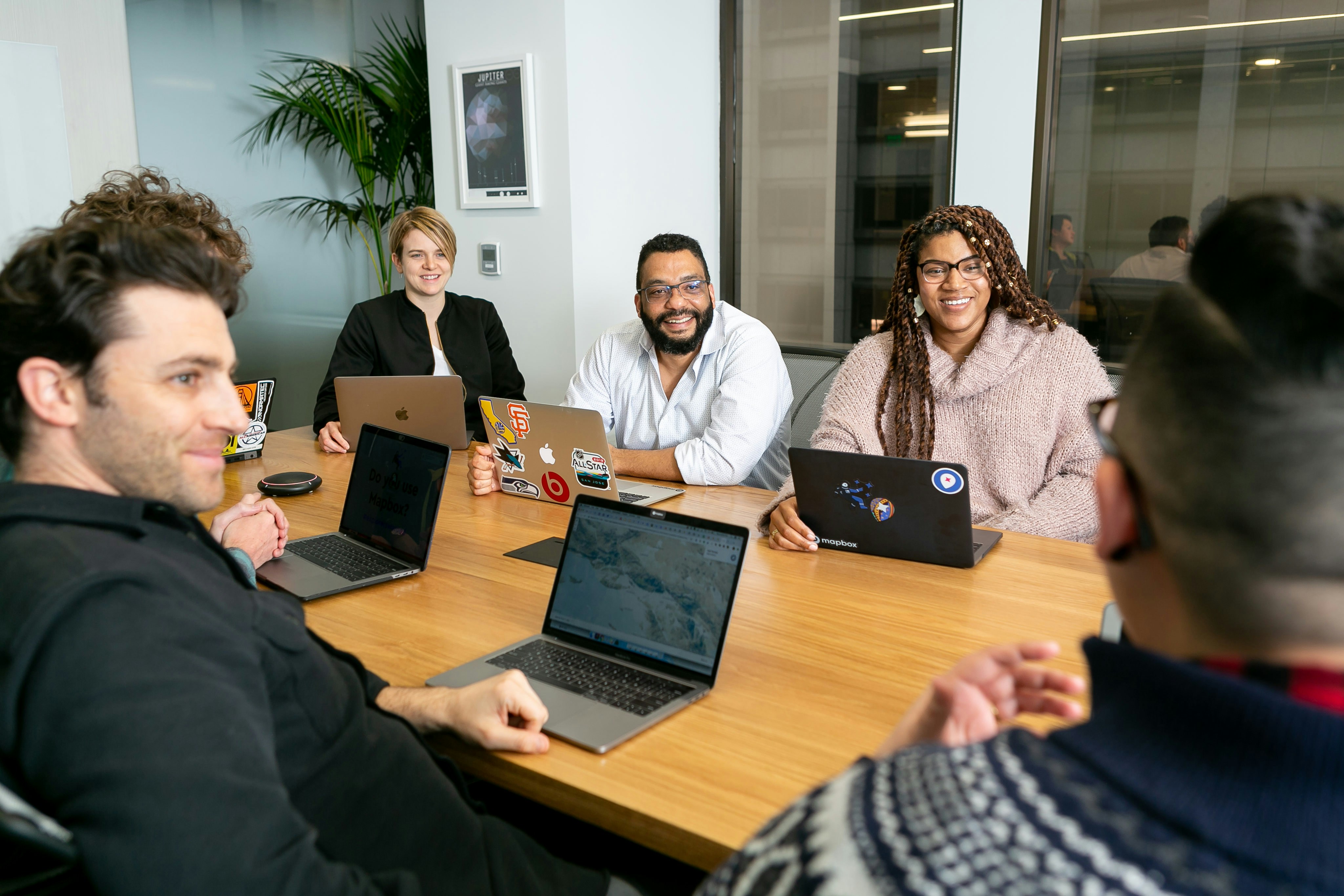 pessoas reunidas em uma mesa com seus notebooks